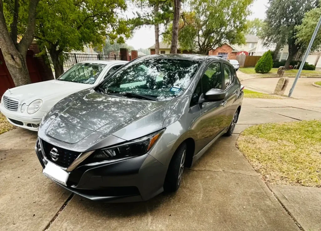 Gray Nissan hatchback parked in a Houston driveway ready for junk car pickup